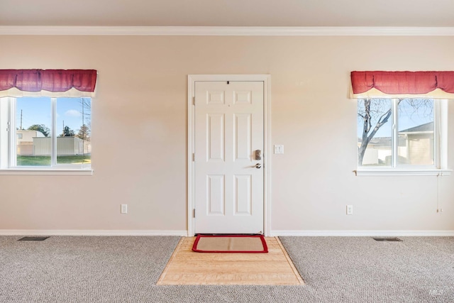 unfurnished room with a wealth of natural light, crown molding, and carpet
