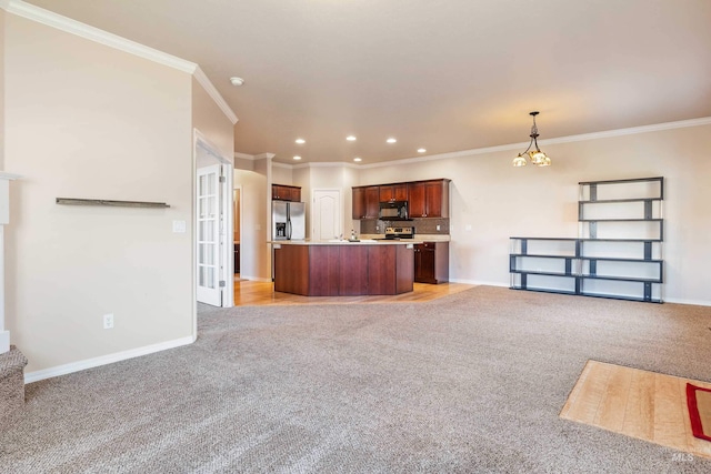 kitchen with crown molding, a center island with sink, hanging light fixtures, and appliances with stainless steel finishes