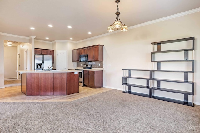 kitchen featuring tasteful backsplash, crown molding, an island with sink, and appliances with stainless steel finishes