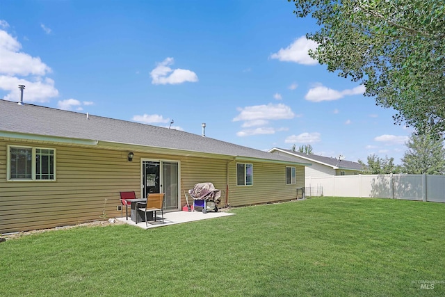 rear view of house with a patio and a yard