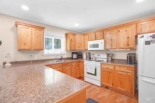 kitchen featuring white appliances, light hardwood / wood-style floors, and sink