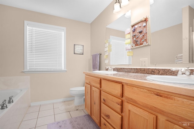 bathroom featuring vanity, a relaxing tiled tub, tile patterned floors, and toilet