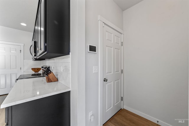 kitchen with tasteful backsplash, range, dark hardwood / wood-style flooring, and light stone counters