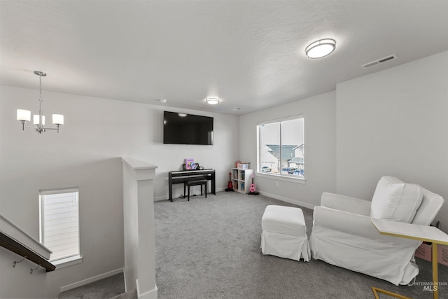 sitting room with a chandelier and carpet