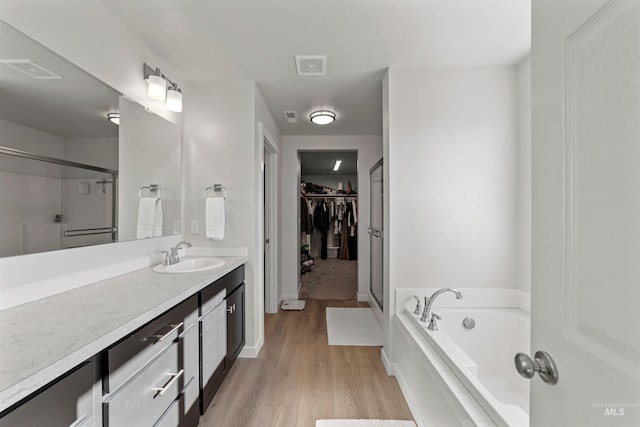 bathroom with vanity, separate shower and tub, and wood-type flooring