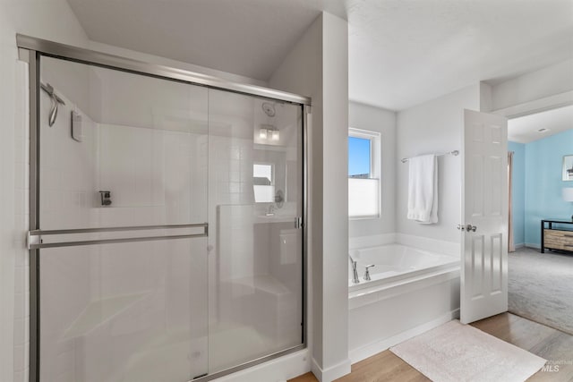 bathroom featuring wood-type flooring and independent shower and bath