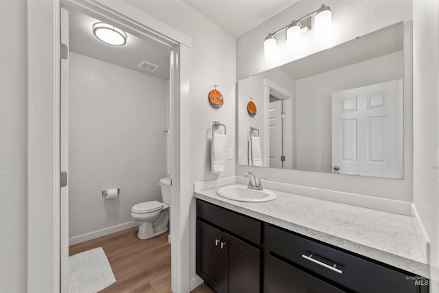 bathroom featuring vanity, hardwood / wood-style flooring, and toilet