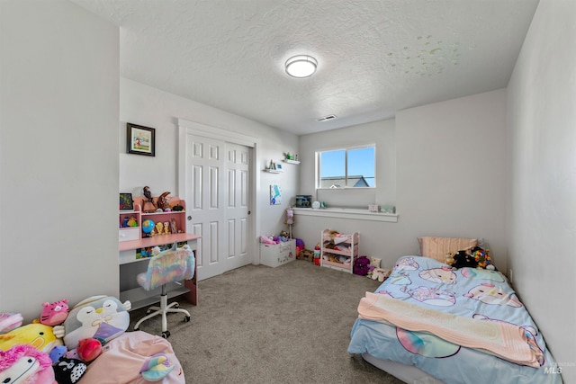 carpeted bedroom with a closet and a textured ceiling