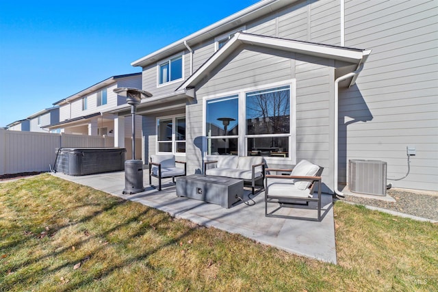 rear view of property with central AC, a yard, a hot tub, and a patio area