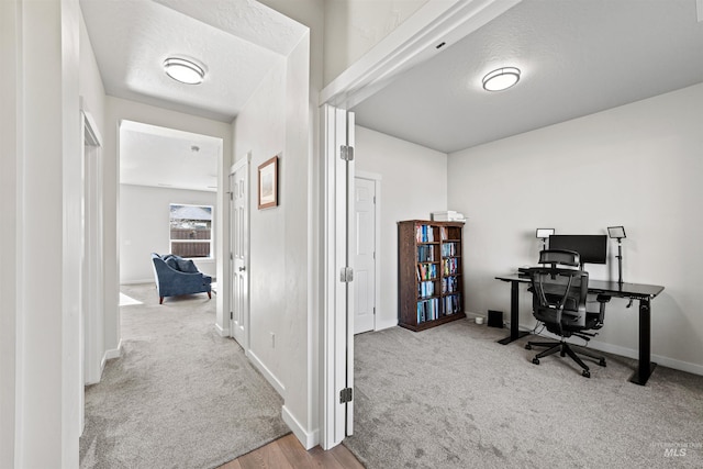 carpeted office with a textured ceiling