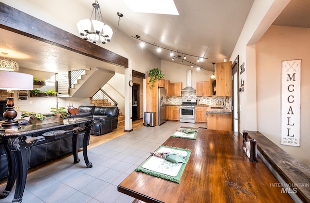 tiled dining room featuring sink, a notable chandelier, and a skylight