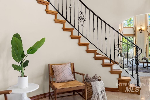 4553 N Arrow Crest Way, Boise, ID 83703 - staircase with baseboards, tile patterned flooring, a high ceiling, and arched walkways
