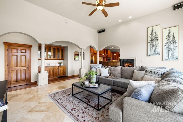 4553 N Arrow Crest Way, Boise, ID 83703 - living room with ornate columns, arched walkways, ceiling fan, recessed lighting, and a glass covered fireplace