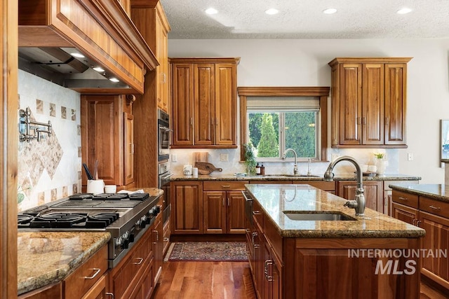 4553 N Arrow Crest Way, Boise, ID 83703 - kitchen featuring a sink, stovetop with downdraft, dark wood-style floors, a center island with sink, and recessed lighting