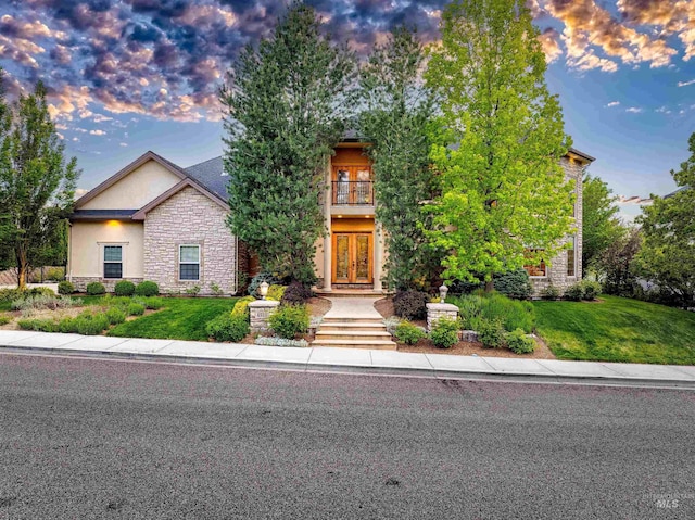 4553 N Arrow Crest Way, Boise, ID 83703 - view of property hidden behind natural elements with french doors, stone siding, stucco siding, a balcony, and a front yard
