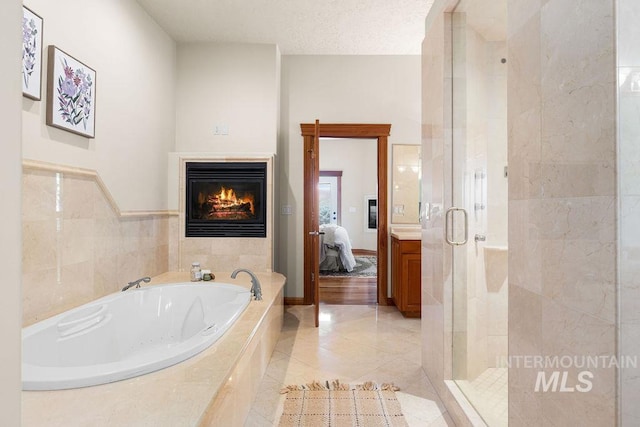 4553 N Arrow Crest Way, Boise, ID 83703 - ensuite bathroom featuring a jetted tub, a fireplace, a stall shower, and tile patterned floors