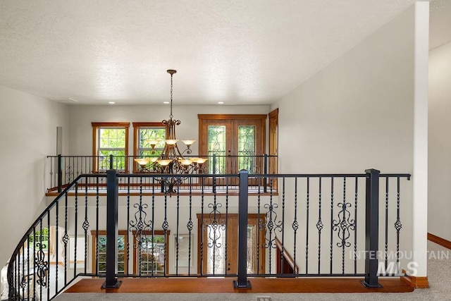 4553 N Arrow Crest Way, Boise, ID 83703 - hallway featuring a chandelier, baseboards, an upstairs landing, and a textured ceiling