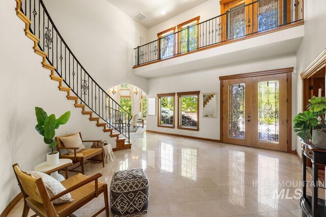 4553 N Arrow Crest Way, Boise, ID 83703 - entrance foyer with french doors, arched walkways, a high ceiling, stairway, and baseboards