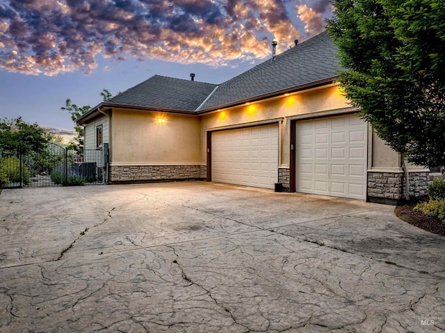 4553 N Arrow Crest Way, Boise, ID 83703 - view of home's exterior featuring stone siding, stucco siding, an attached garage, and concrete driveway