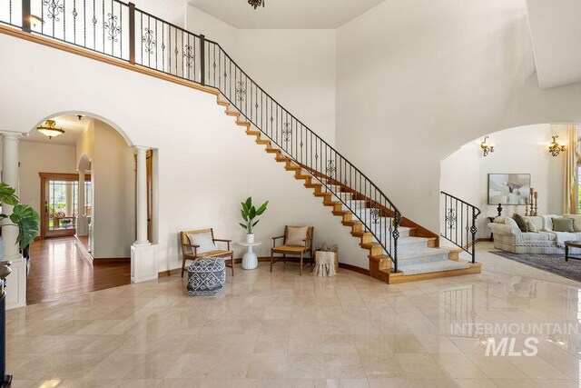 4553 N Arrow Crest Way, Boise, ID 83703 - foyer entrance with arched walkways, ornate columns, a towering ceiling, stairway, and baseboards