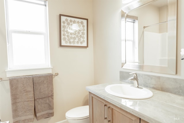 full bath featuring toilet, a shower, and vanity