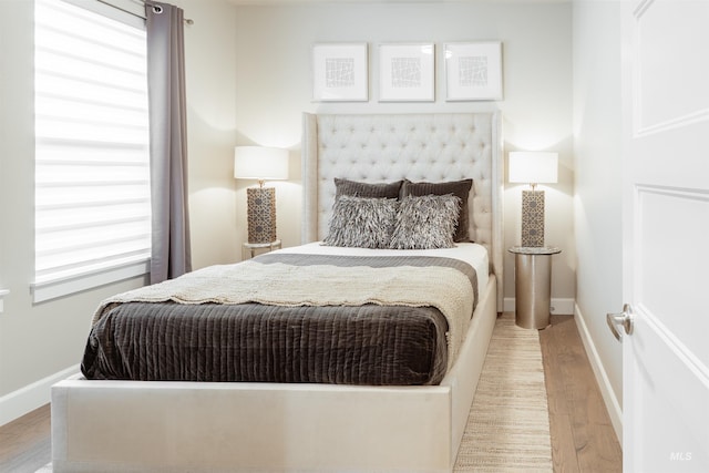 bedroom featuring wood finished floors and baseboards