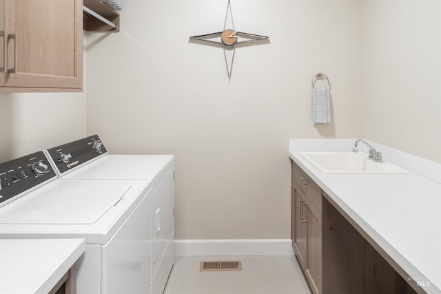 clothes washing area featuring washer and dryer, cabinet space, a sink, baseboards, and visible vents