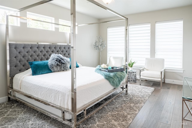 bedroom with baseboards and hardwood / wood-style flooring