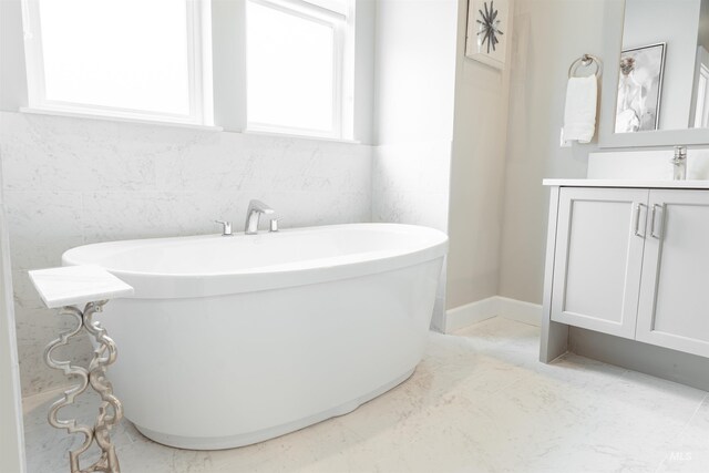 full bathroom with a soaking tub and vanity