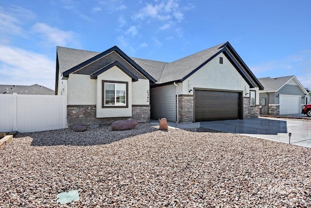 view of front of home with fence, driveway, an attached garage, stucco siding, and stone siding