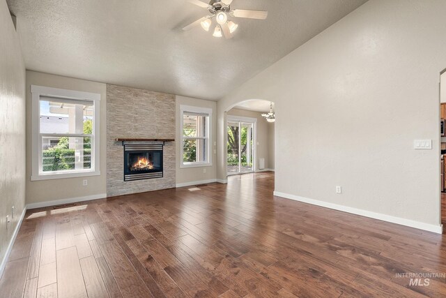 613 E Sable Ridge Dr, Kuna, ID 83634 - unfurnished living room with a fireplace, plenty of natural light, a ceiling fan, arched walkways, and lofted ceiling