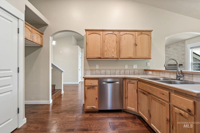 613 E Sable Ridge Dr, Kuna, ID 83634 - kitchen featuring dishwasher, a sink, vaulted ceiling, arched walkways, and light countertops