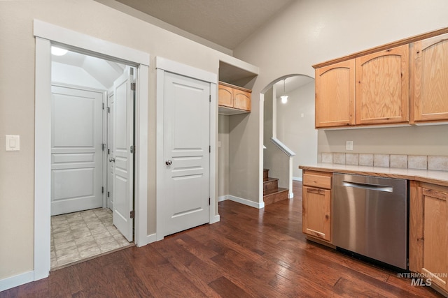 613 E Sable Ridge Dr, Kuna, ID 83634 - kitchen with stainless steel dishwasher, dark wood-style flooring, light brown cabinets, arched walkways, and baseboards
