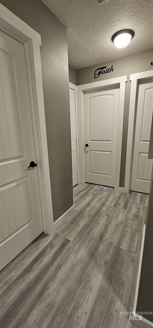 1122 N Roper Pl, Meridian, ID 83642 - hall featuring wood finished floors, a textured ceiling, and baseboards
