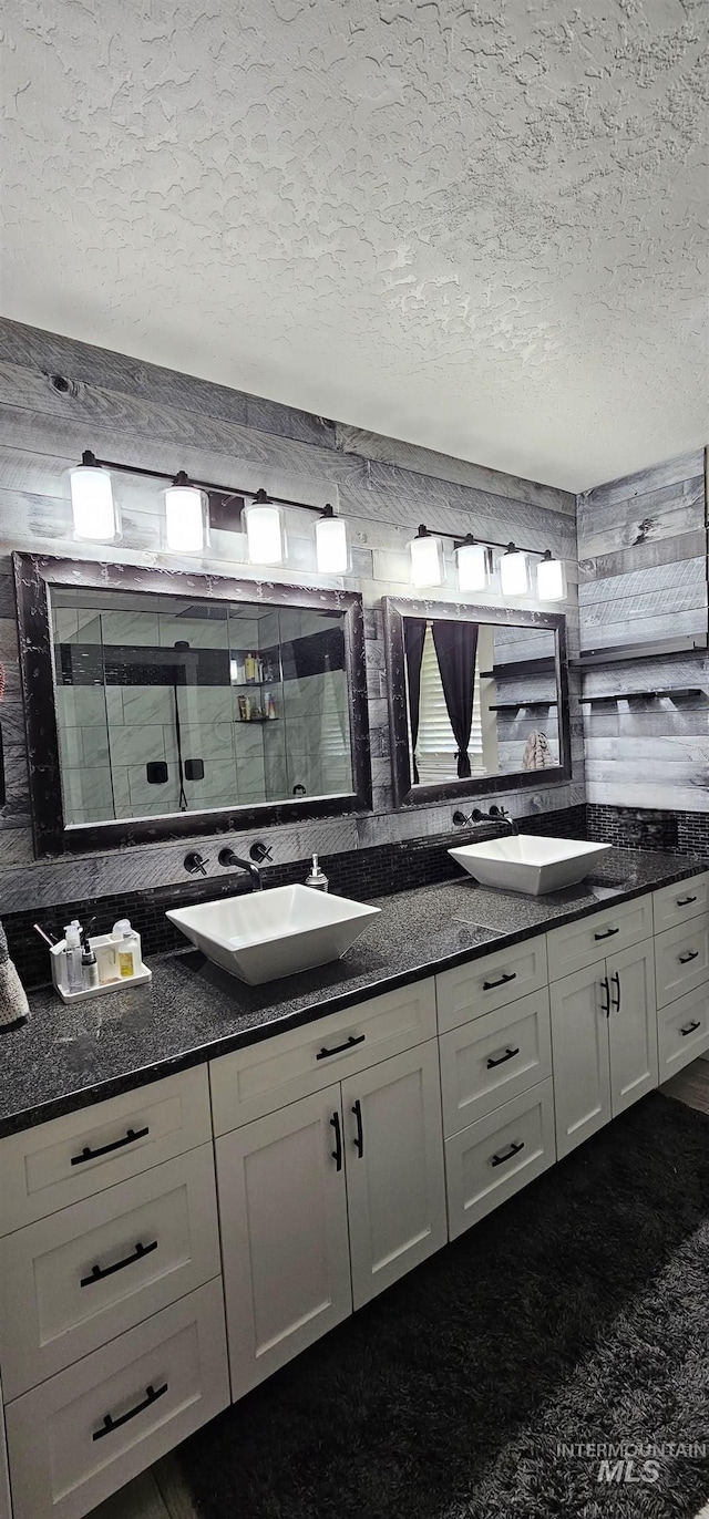 1122 N Roper Pl, Meridian, ID 83642 - bathroom featuring double vanity, a textured ceiling, backsplash, and a tile shower