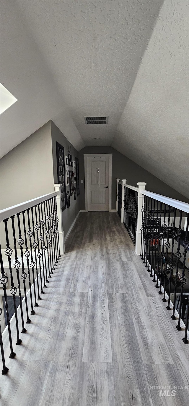 1122 N Roper Pl, Meridian, ID 83642 - corridor featuring a textured ceiling, wood finished floors, lofted ceiling, and baseboards