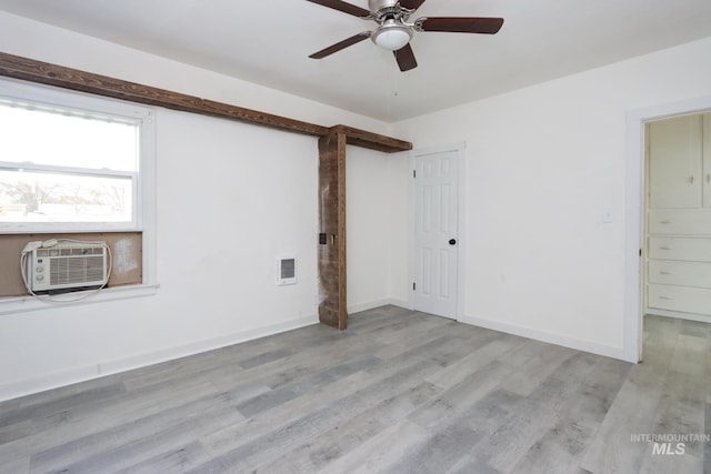 empty room with baseboards, cooling unit, visible vents, ceiling fan, and wood finished floors