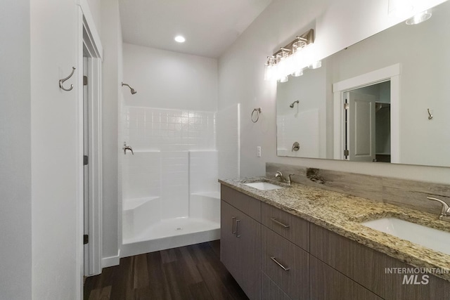 bathroom featuring wood finished floors, a sink, and a shower