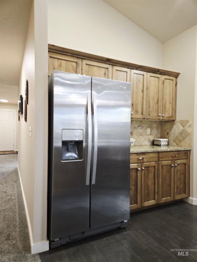 2716 Dogwood Ave, Fruitland, ID 83619 - kitchen with stainless steel fridge with ice dispenser, vaulted ceiling, tasteful backsplash, baseboards, and light stone countertops
