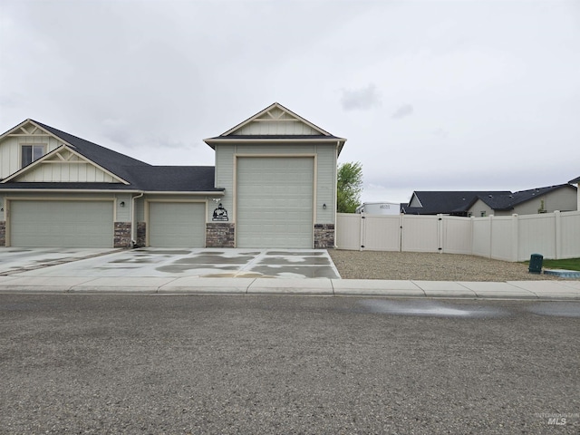 2716 Dogwood Ave, Fruitland, ID 83619 - view of front of house with a garage, a gate, concrete driveway, board and batten siding, and stone siding
