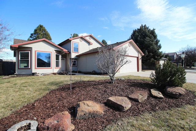 exterior space featuring a lawn, an attached garage, concrete driveway, and fence