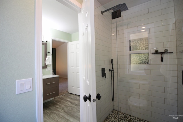 bathroom with vanity, wood finished floors, and a shower stall