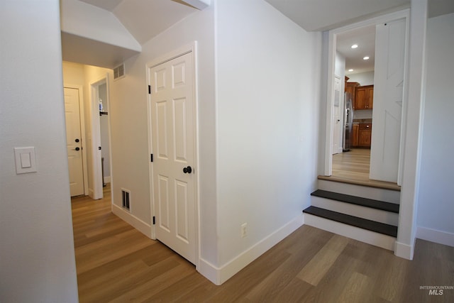 hall with visible vents, recessed lighting, baseboards, and light wood-type flooring