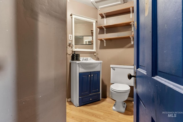 bathroom with vanity, toilet, and hardwood / wood-style floors