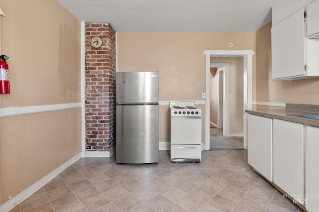 kitchen with electric stove, white cabinetry, and stainless steel fridge