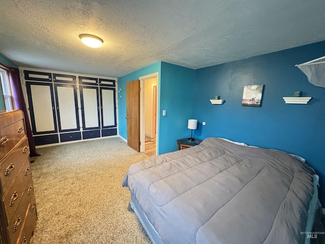 bedroom with light colored carpet and a textured ceiling