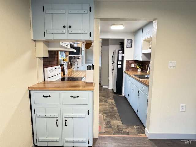 kitchen featuring tasteful backsplash, sink, white electric range, white cabinetry, and fridge