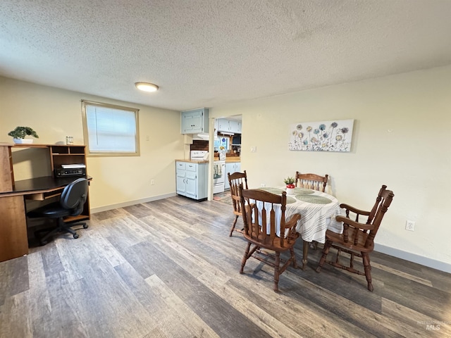 dining area featuring wood-type flooring and a textured ceiling