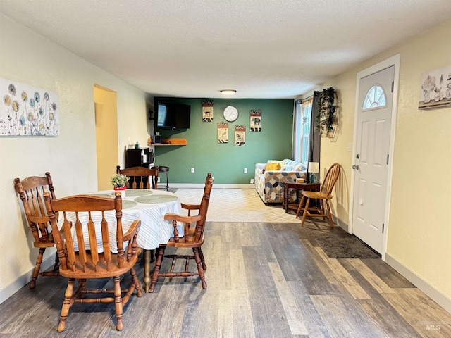 dining area featuring a textured ceiling and hardwood / wood-style flooring