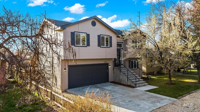 view of front of property featuring a front lawn, fence, driveway, and an attached garage